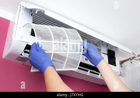 Klimaanlage reinigen. Mann in Handschuhen prüft den Filter. Stockfoto