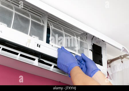 Klimaanlage reinigen. Mann in Handschuhen prüft den Filter. Stockfoto