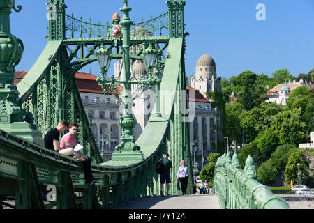 Ungarn, Budapest. Die Freiheitsbrücke. Studenten sitzen auf der Brücke Stockfoto