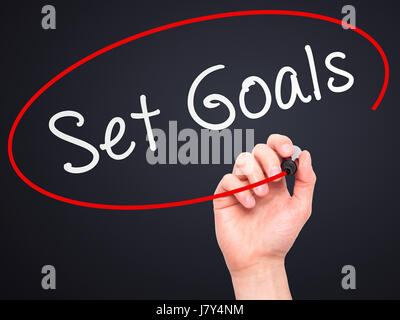 Hand des Menschen setzen Ziele auf Bildschirm zu schreiben. Geschäft, Hilfe, Internet, Technologie-Konzept. Isoliert auf schwarz. Stock Foto Stockfoto
