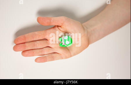 weibliche Hand zeigen kleine grüne Plastilin monster Stockfoto