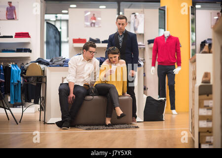 Gruppe von Freunden auf Shopping Walk auf Shopping Centre mit einem Mobiltelefon für Ideen Stockfoto