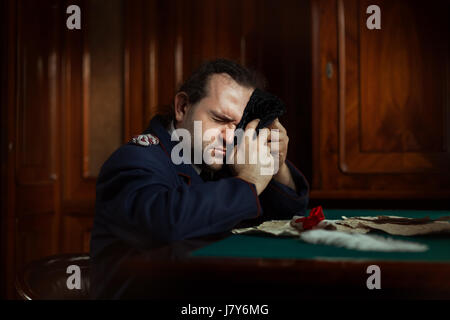 Mann sitzt am Tisch-Weinen.  Auf dem Tisch liegen seine Briefe, Retro-Stil. Stockfoto