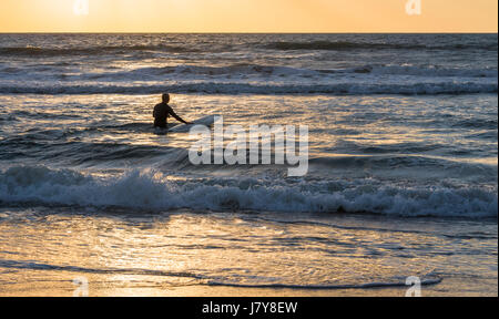 Florida-Surfer Position heraus in die Wellen für ein Sunrise Surf-Session in Ponte Vedra Beach. (USA) Stockfoto