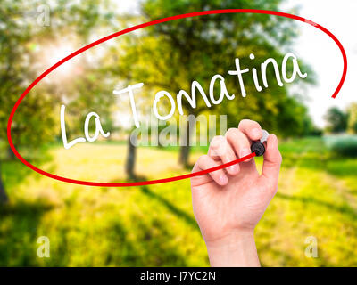 Hand des Mannes La Tomatina mit schwarzem Filzstift auf Bildschirm zu schreiben. Isoliert auf Natur. Wirtschaft, Technologie, Internet-Konzept. Stockfoto