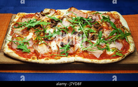 Große Pizza mit gegrillten Champignons und geräuchertem Schinken. Stockfoto