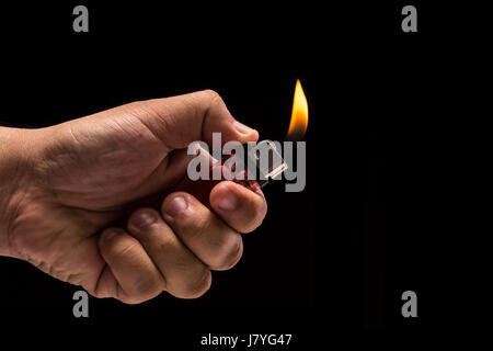 Hand mit brennenden Gasfeuerzeug hautnah. Studio gedreht isolierten auf schwarzen Hintergrund Stockfoto