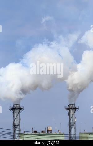 Hohe weiße Industriedampf in Fabrik am blauen Himmel Stockfoto