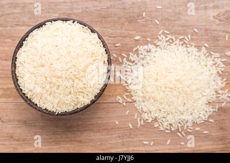 Draufsicht Thai Jasminreis in Holzschale auf Holzbrett Hintergrund setzen Stockfoto