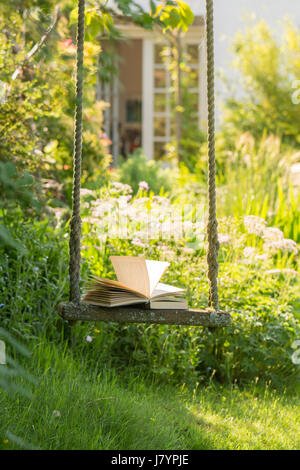 Öffnen Sie Adressbuch auf Gartenschaukel im Königreich Garten hinter dem Haus Stockfoto