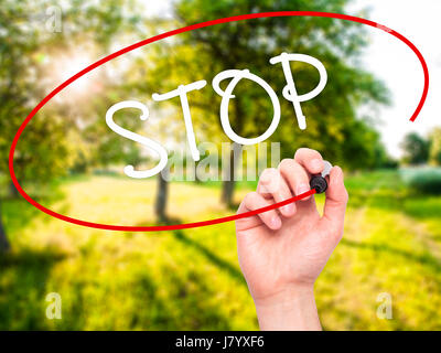 Hand des Mannes STOP mit schwarzem Filzstift auf Bildschirm zu schreiben. Auf Hintergrund isoliert. Wirtschaft, Technologie, Internet-Konzept. Stock Foto Stockfoto