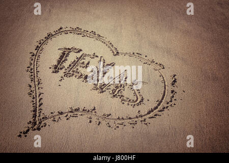 Das Wort Texas und Herz auf den Strandsand gezeichnet. Liebe-Texas-Konzept. Stockfoto