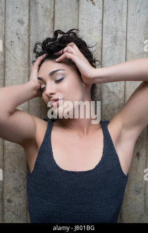 Frau auf dem Boden Kopf in Händen Schmerzen Festlegung Stockfoto