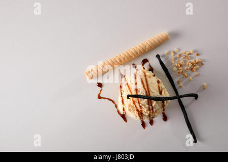 Eis Vanille Textur Hintergrund mit Kugel isoliert auf weißen Tisch gewürzt. Garniert mit Vanille, Mandeln und Karamell. Ansicht von oben. Horizont Stockfoto