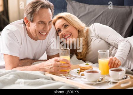 Mittleren Alter Brautpaar zusammen im Bett frühstücken Stockfoto