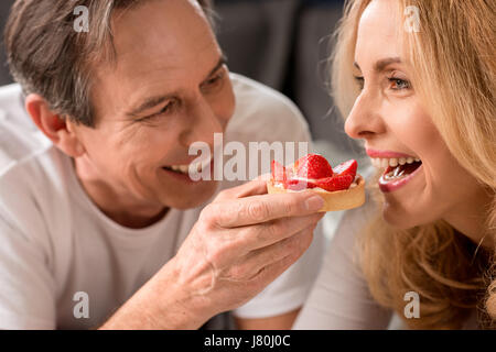 Nahaufnahme von lächelnden Mann Fütterung schöne blonde Frau am Morgen Stockfoto