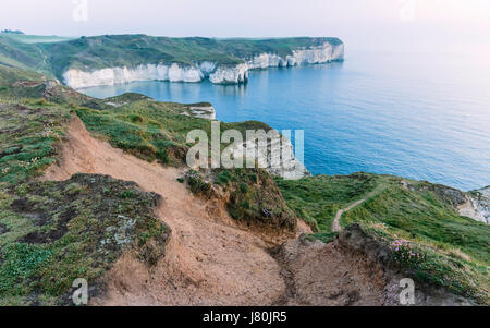 Meer und Wetter Erosion entlang der hohen Kreidefelsen auf einem feinen Sonnenaufgang mit Blick auf eine ruhige Nordsee in der Nähe von Flamborough Head, Flamborough, Yorkshire, Großbritannien. Stockfoto