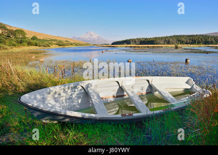 Irland, County Donegal, Clady River mit Mount Errigal in der Ferne und ein Ruderboot im Vordergrund. Stockfoto