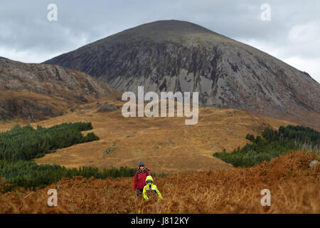 Mutter und Sohn wandern vor der schottischen Berge, Schottland, Großbritannien. Stockfoto