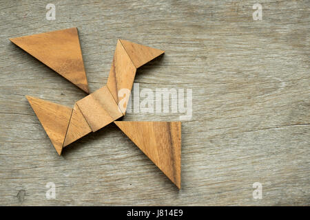 Mann halten Dreieck, Tangram-Puzzle in Vogel-Form zu erfüllen (Konzept für die Freiheit, frei leben oder entdecken Sie neue Welt) Stockfoto