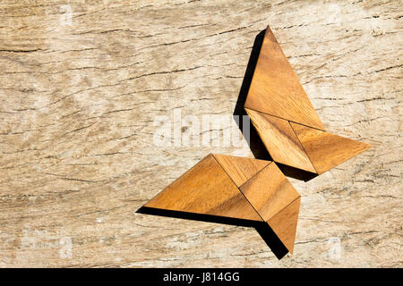 Hölzerne Tangram puzzle in fliegender Schmetterling Form Hintergrund Stockfoto