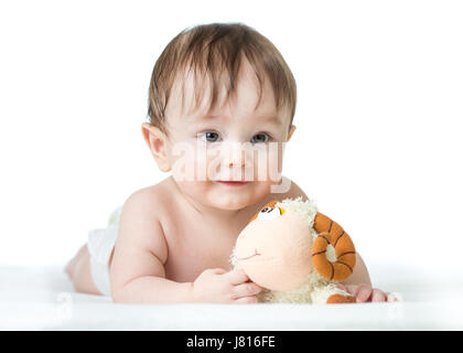 Baby Boy auf Bauch liegend mit Plüsch-Spielzeug Stockfoto