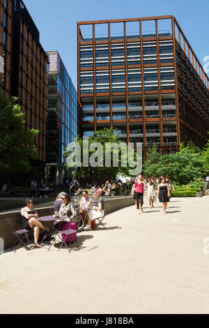 Büroangestellte entspannen in Pancras Square in der Nähe von Google HQ in King's Cross, London, England, Großbritannien Stockfoto