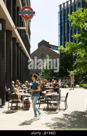 Büroangestellte entspannen in Pancras Square in der Nähe von Google HQ in King's Cross, London, England, Großbritannien Stockfoto