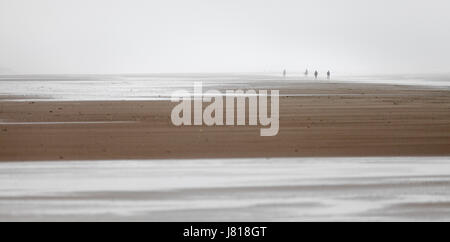 Reiter und Wanderer in der Ferne auf dem Sand in Holkham Bay an der Küste von Norfolk. Stockfoto