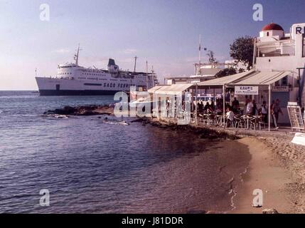 Chora, Mykonos, Griechenland. 3. Oktober 2004. Eine Fähre geht belebten Cafés säumen die Bucht in Mykonos. Tourismus ist ein wichtiger Wirtschaftszweig und Mykonos lockt zahlreiche Besucher jedes Jahr. Bildnachweis: Arnold Drapkin/ZUMA Draht/Alamy Live-Nachrichten Stockfoto