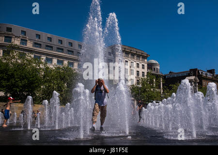 Manchester, UK. 26. Mai 2017. Großbritannien Wetter. Ein junger Mann spielt in der neu renovierten Brunnen in Piccadilly Gardens, Manchester, England zur Abkühlung an einem schönen heißen Tag. Foto Ian Walker/Alamy News. Bildnachweis: Ian Walker/Alamy Live-Nachrichten Stockfoto