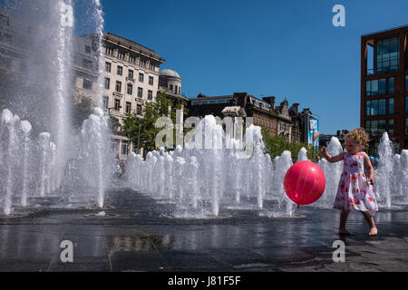 Manchester, UK. 26. Mai 2017. Großbritannien Wetter. Ein junges Mädchen mit einem Ballon spielt in der Nähe der neu renovierten Brunnen in Piccadilly Gardens, Manchester, England zur Abkühlung an einem schönen heißen Tag. Foto Ian Walker/Alamy News. Bildnachweis: Ian Walker/Alamy Live-Nachrichten Stockfoto