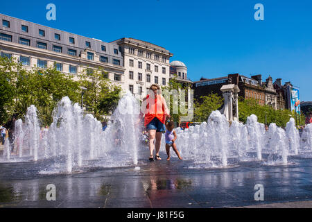 Manchester, UK. 26. Mai 2017. Großbritannien Wetter. Ein kleines Kind und eine Frau in den neu renovierten Brunnen in Piccadilly Gardens, Manchester, England zur Abkühlung an einem schönen heißen Tag zu spielen. Foto Ian Walker/Alamy News. Bildnachweis: Ian Walker/Alamy Live-Nachrichten Stockfoto