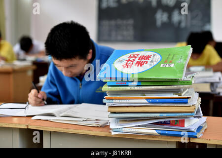 (170527)--LINFEN, 27. Mai 2017 (Xinhua)--Senioren überprüfen Sie Unterricht an der Red Ribbon School in Linfen, Nord-China Shanxi Provinz, 25. Mai 2017. Die Schule namens "Red Ribbon", das HIV/AIDS-Bewusstsein-Symbol wurde 2011 gegründet. Es ist früher ein Klassenzimmer von Linfen Nr. 3 Volks Krankenhaus statt. Insgesamt 36 HIV-Träger-Studenten in drei Klassen in der Schule Leben. Kinder könnten medizinische Behandlung sowie psychologische Ausbildung und akademische Ausbildung an der Schule erhalten. Sechzehn Senioren der Schule besuchte ihre Abschlussfeier am Freitag und beteiligen sich an der diesjährigen national Stockfoto