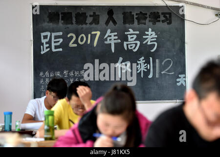 (170527)--LINFEN, 27. Mai 2017 (Xinhua)--Senioren überprüfen Sie Unterricht an der Red Ribbon School in Linfen, Nord-China Shanxi Provinz, 25. Mai 2017. Die Schule namens "Red Ribbon", das HIV/AIDS-Bewusstsein-Symbol wurde 2011 gegründet. Es ist früher ein Klassenzimmer von Linfen Nr. 3 Volks Krankenhaus statt. Insgesamt 36 HIV-Träger-Studenten in drei Klassen in der Schule Leben. Kinder könnten medizinische Behandlung sowie psychologische Ausbildung und akademische Ausbildung an der Schule erhalten. Sechzehn Senioren der Schule besuchte ihre Abschlussfeier am Freitag und beteiligen sich an der diesjährigen national Stockfoto