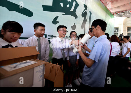 (170527)--LINFEN, 27. Mai 2017 (Xinhua)--Studierende präsentieren Souvenirs für wissenschaftliches Personal während einer Abschlussfeier an der Red Ribbon School in Linfen, Nord-China Shanxi Provinz, 26. Mai 2017. Die Schule namens "Red Ribbon", das HIV/AIDS-Bewusstsein-Symbol wurde 2011 gegründet. Es ist früher ein Klassenzimmer von Linfen Nr. 3 Volks Krankenhaus statt. Insgesamt 36 HIV-Träger-Studenten in drei Klassen in der Schule Leben. Kinder könnten medizinische Behandlung sowie psychologische Ausbildung und akademische Ausbildung an der Schule erhalten. Sechzehn Senioren der Schule besuchte ihre Graduierung Zeremonie o Stockfoto