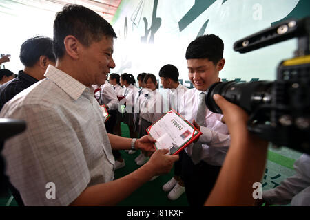 (170527)--LINFEN, 27. Mai 2017 (Xinhua)--Studenten erhalten Abschluss Zertifikate während einer Abschlussfeier an der Red Ribbon School in Linfen, Nord-China Shanxi Provinz, 26. Mai 2017. Die Schule namens "Red Ribbon", das HIV/AIDS-Bewusstsein-Symbol wurde 2011 gegründet. Es ist früher ein Klassenzimmer von Linfen Nr. 3 Volks Krankenhaus statt. Insgesamt 36 HIV-Träger-Studenten in drei Klassen in der Schule Leben. Kinder könnten medizinische Behandlung sowie psychologische Ausbildung und akademische Ausbildung an der Schule erhalten. Sechzehn Senioren der Schule besuchte ihre Abschlussfeier am Fr Stockfoto