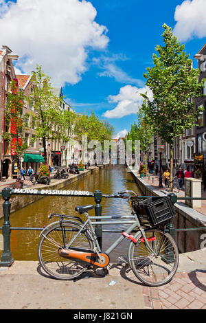 AMSTERDAM, Niederlande - 23. Juni 2013: Belebte Straße (Oudezijds Achterburgwal) im Herzen der Rotlichtviertel in Amsterdam, Niederlande. Her ansehen Stockfoto