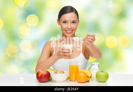 glückliche Frau mit Obst, Müsli, Joghurt essen Stockfoto
