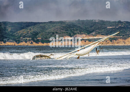 Ein Segelboot, das in Coronado, Kalifornien am Strand angespült. Stockfoto