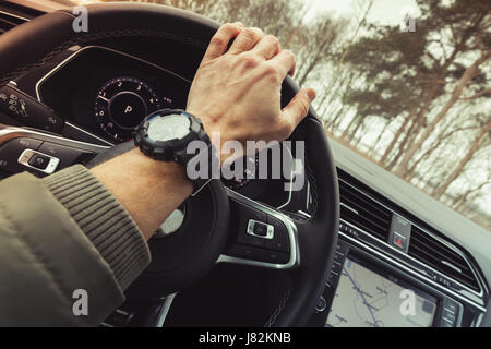 Fahrer-Hand hält Lenkrad der Luxus-Crossover-Auto. Nahaufnahme Foto mit Tiefenschärfe und warmen Tonwertkorrektur Filtereffekt Stockfoto