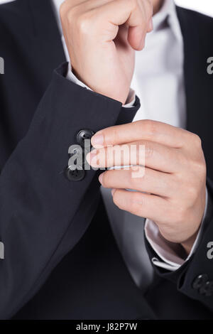 Unternehmen der Hand im schwarzen Anzug putzt sich Stockfoto