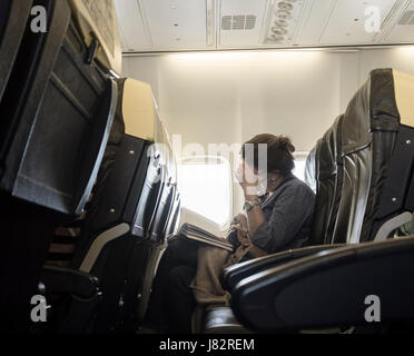 Ryanair-Flug: Reife Frau Lesebuch in Fensterplatz. Stockfoto