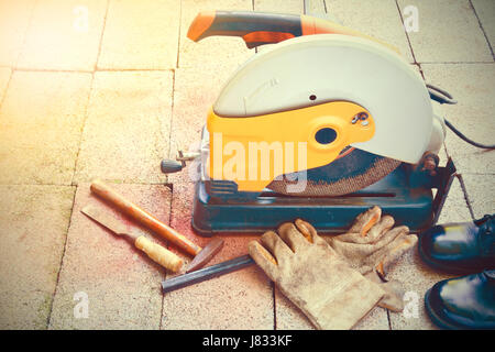 Schneidwerkzeug, Handschuhe, Hammer, Meißel und Schuhe anziehen Ziegel unter der Sonne-Vintage-Stil Stockfoto