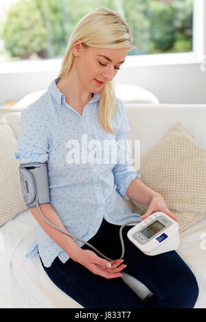 Frau, die ihre eigenen Blutdruck überprüfen Stockfoto