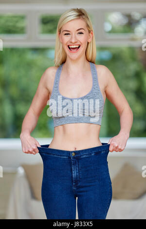 Mädchen mit großen Jeans - Gewicht-Verlust Stockfoto