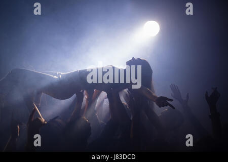 Crowdsurfing bei einem Konzert in Nachtclub Stockfoto