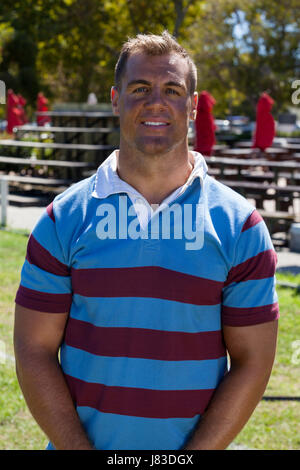 Porträt des Lächelns Rugby-Spieler, die an sonnigen Tag am Spielfeld stehen Stockfoto