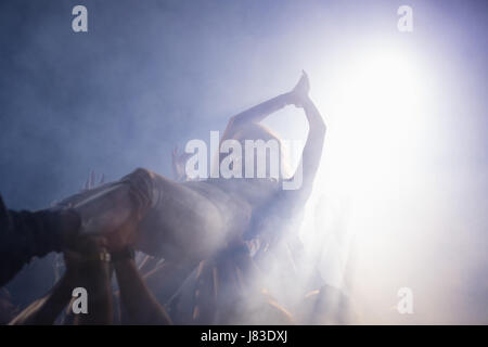 Crowdsurfing bei einem Konzert in Nachtclub Stockfoto