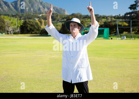 Niedrigen Winkel Blick auf Kricket-Schiedsrichter Signalisierung mit sechs Spiel an sonnigen Tag Stockfoto